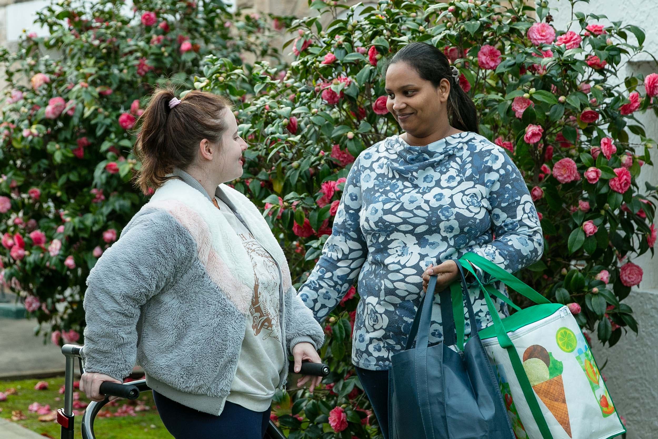 Allcare Support worker helping young woman.